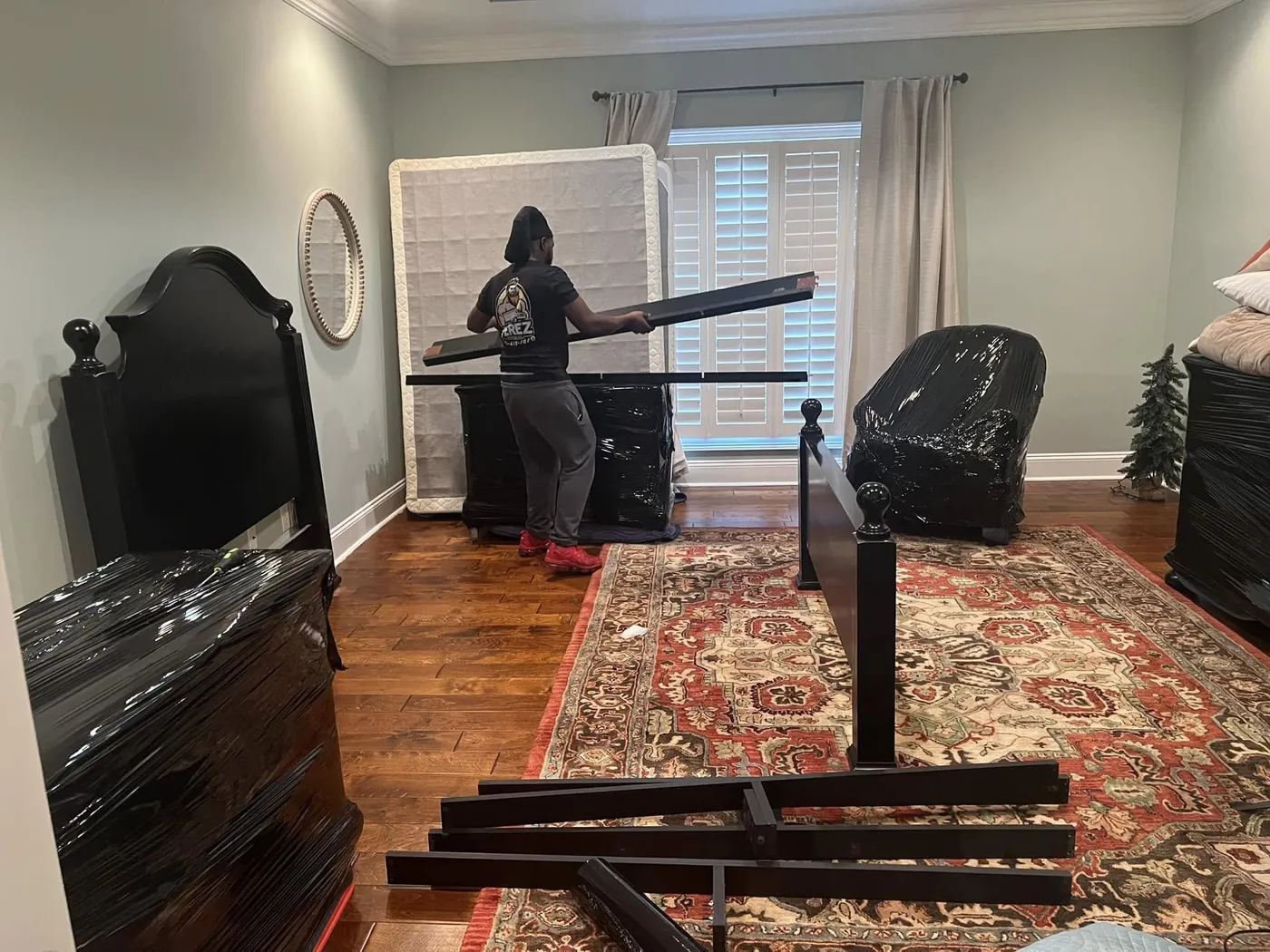 Perez Moving Co mover handling a wrapped mirror inside a customer's home
