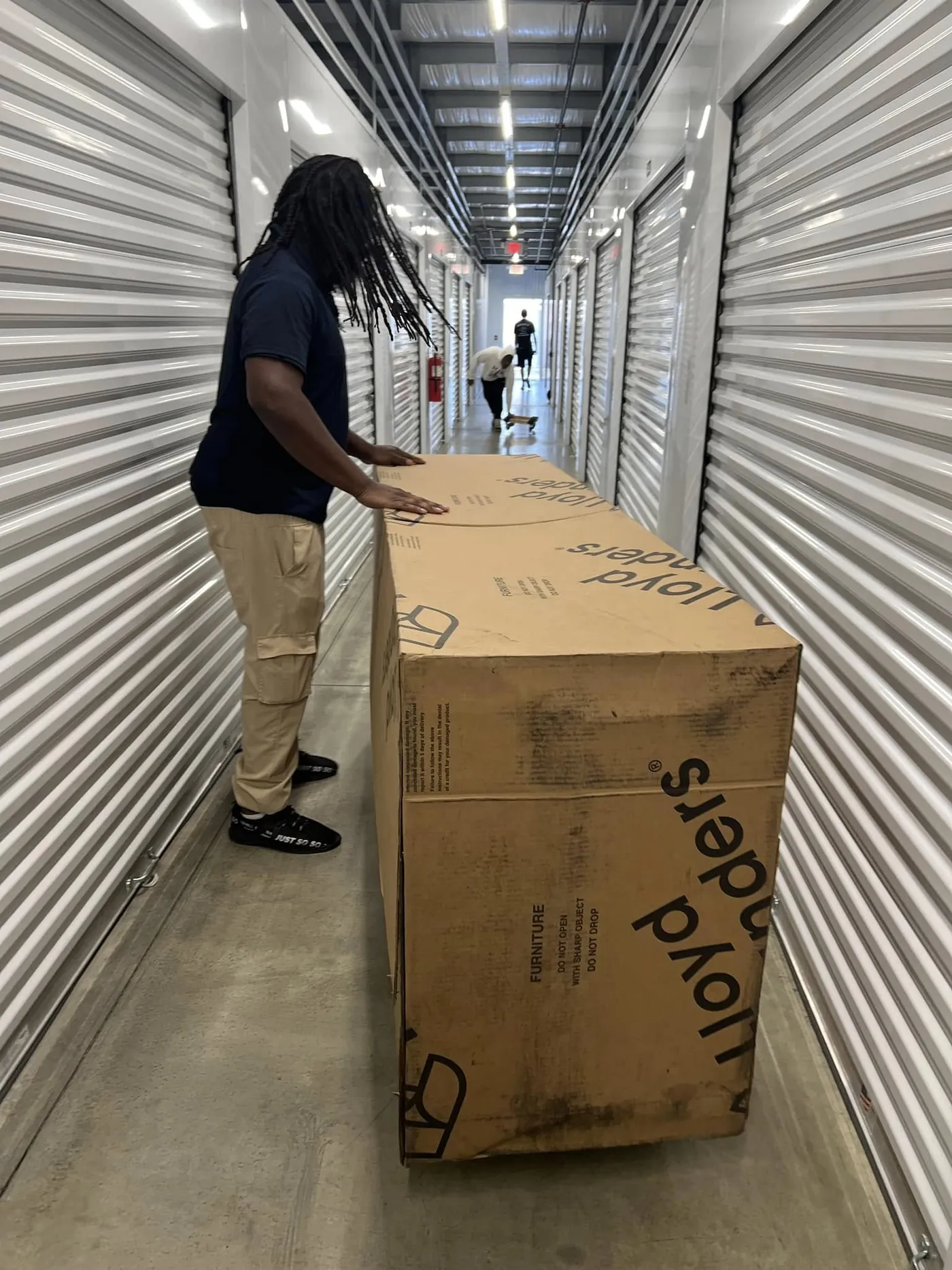 Perez Moving Co mover with a wrapped dresser at a storage unit
