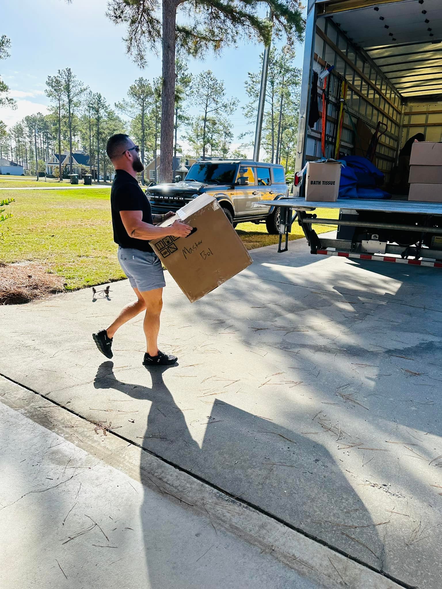 Owner of Perez Moving Co — carrying a box beside the company truck in Valdosta, GA